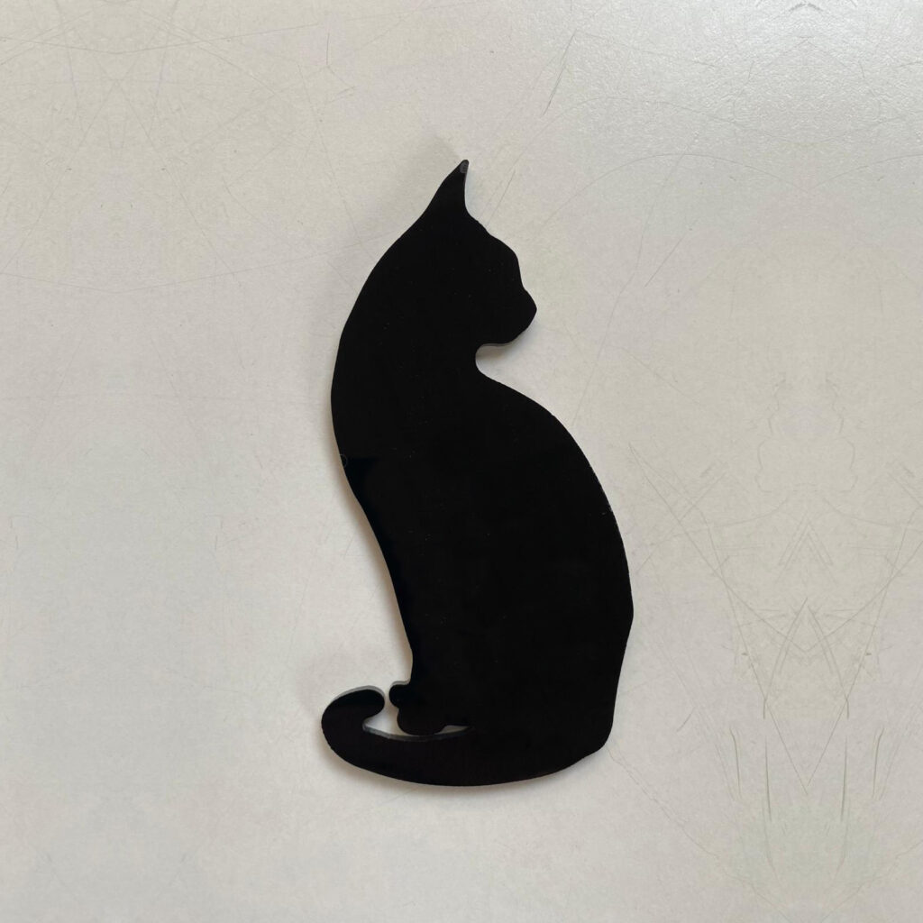 Een door Ans Markus ontworpen broche in de vorm van een zittende zwarte poes